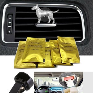 Puede incluir: Un juego de cuatro ambientadores de coche en bolsas de papel de aluminio dorado con diferentes aromas: sabor a melocotón, lavanda, limón y floral. Las bolsas están etiquetadas en caracteres chinos. Se muestran dos clips de ventilación de coche de plástico negro, uno con una vista de cerca y el otro en un coche.