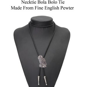 May include: A black bolo tie with a silver owl pendant. The tie is made from fine English pewter.
