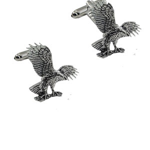 May include: A pair of silver eagle cufflinks. The eagles are in flight with their wings spread wide. The cufflinks are a great way to add a touch of style to any outfit.