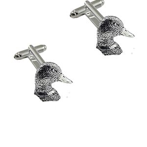 May include: A pair of silver cufflinks featuring a detailed engraved image of a duck's head.