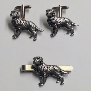 Könnte beinhalten: Ein Set silberfarbener Manschettenknöpfe und ein Krawattenclip mit einem detaillierten Golden Retriever-Hundedesign.