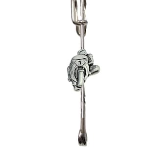 Könnte beinhalten: Silberfarbener Ansteckpin mit einer detaillierten Darstellung eines Motorradrennfahrers in der Fahrt. Der Pin hat einen Sicherheitsverschluss.