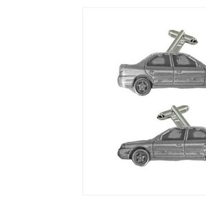 Puede incluir: Un par de gemelos de plata con un diseño de coche en miniatura detallado. Los gemelos son un accesorio único y elegante para cualquier entusiasta del automóvil.