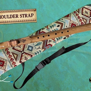 Könnte beinhalten: Holzflöte mit dekorativer Hülle mit geometrischem Muster in Braun-, Rot- und Blautönen. Die Flöte hat einen schwarzen Schultergurt und der Text "SHOULDER STRAP" ist sichtbar.