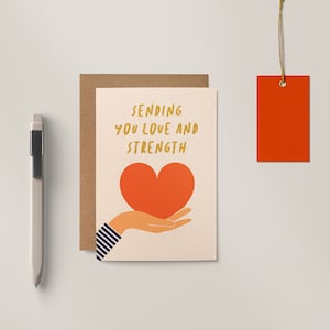 Sympathy card with a hand holding a red heart and text that says sending you Love and strength