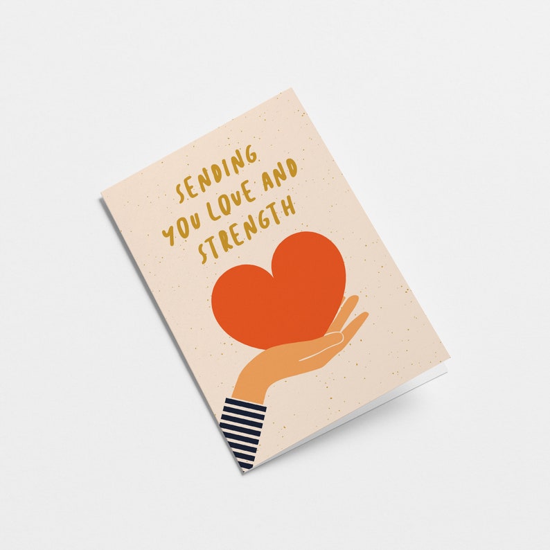 Sympathy card with a hand holding a red heart and text that says sending you Love and strength