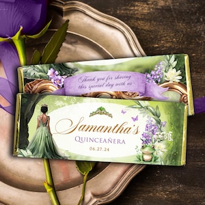 May include: Two chocolate bar wrappers with a quinceañera theme. One wrapper has the text "Thank you for sharing this special day with us" on a purple banner. The other wrapper has the name "Samantha's Quinceañera" and the date 06.27.24.