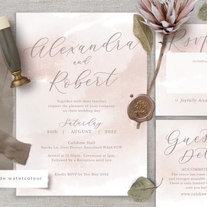 May include: Wedding invitation with a watercolor background in shades of pink and white. The invitation features the names "Alexandra and Robert" in elegant script. The text includes the date, time, and location of the wedding, as well as a request for RSVP by May 21st, 2022.