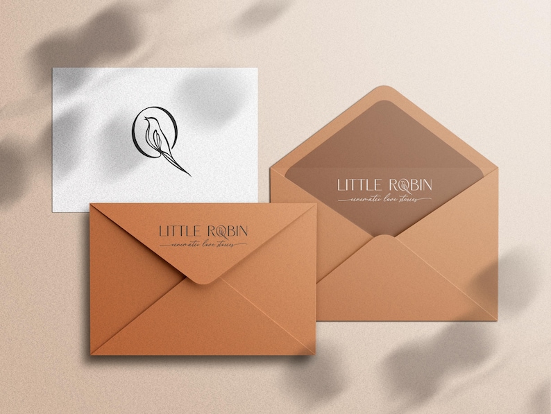 May include: A brown envelope with the text "LITTLE ROBIN - minimalist fine jewelry" printed on the front. The envelope is sitting on a beige surface.