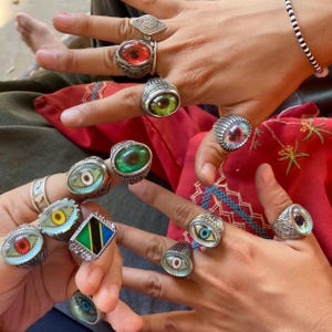 Anillo tribal masái con forma de ojo, joyería metálica artesanal, inspirada en el trabajo con cuentas, regalo cultural de Tanzania.