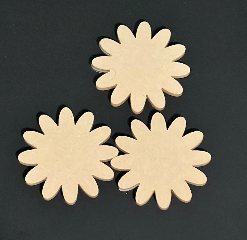 May include: Three unfinished wooden flower-shaped cutouts. The cutouts are beige and have a smooth surface.