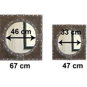May include: Two square-shaped mirrors with a round mirror inside. The larger mirror measures 67 cm by 67 cm and the smaller mirror measures 47 cm by 47 cm. Both mirrors have a rustic, industrial look with a dark brown metal frame and silver rivets.