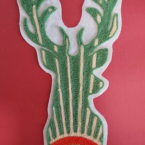 May include: Green and white embroidered deer head patch with a brown eye. The patch has the text "Circa 1975" and "Fantastick Embroidery" on the top.