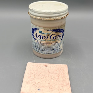 May include: A jar of Mayco Astro Gem brush-on textural glaze in Soft Coral, and a matching coral-coloured ceramic tile. The jar has a white lid and a label with blue and white text. The tile is square with a hole.