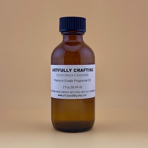 May include: A brown glass bottle with a black cap, labeled "Artfully Crafting California Cannabis Premium Grade Fragrance Oil 2 fl oz (59.14 ml)".