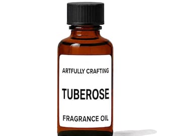 May include: An amber glass bottle with a black ribbed screw cap containing fragrance oil. The white rectangular label features the black text ARTFULLY CRAFTING, TUBEROSE, and FRAGRANCE OIL in a clean, sans-serif font centered on the bottle.