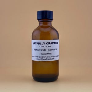 May include: A 2-ounce amber glass bottle with a black cap, labeled "Artfully Crafting Chocolate Premium Grade Fragrance Oil".