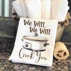 May include: White kitchen towel with a brown crockpot illustration and the text "We Will, We Will Crock You".