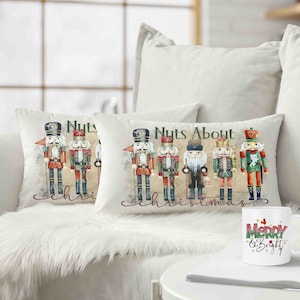 Op de afbeelding: Twee witte kussens met een vintage-illustratie van notenkrakers en de tekst "Nuts About Christmas". Een witte mok met de tekst "Merry & Bright" staat op een tafel voor de kussens.