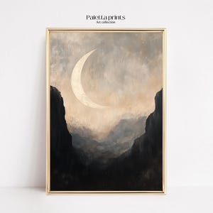 Pode incluir: Uma impressão de arte digital que apresenta uma lua crescente de cor dourada pálida sobre um fundo de montanhas nebulosas. As montanhas são escuras e o céu é de um cinza suave e apagado.