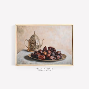 Puede incluir: Una pintura de bodegón con una tetera de plata con un diseño ornamentado y un plato de dátiles. La pintura está enmarcada en un marco dorado y tiene un fondo beige claro.