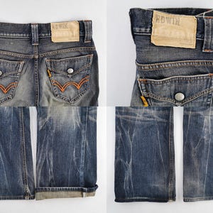 Op de afbeelding: Close-up van een verbleekte blauwe spijkerbroek met oranje stiksels op de achterzakken. De jeans hebben een versleten look, met een leren patch op de tailleband. De merknaam "EDWIN" is zichtbaar op de patch.