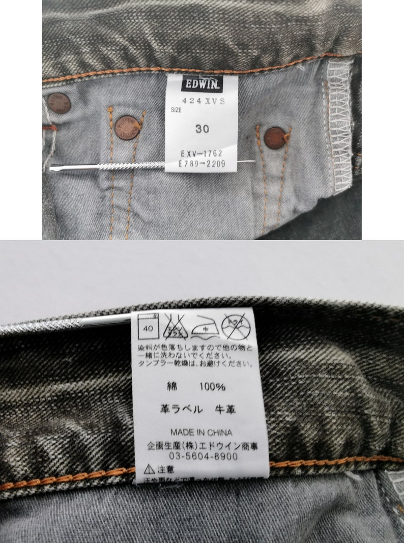 May include: Close-up of the inside of a pair of gray denim jeans. The jeans have a tag with the brand "EDWIN" and the size "30". The tag also includes care instructions and material information.