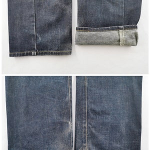 May include: Detailed view of dark wash denim jeans. The image displays the hems and cuffs of the jeans. One cuff is turned up, exposing the lighter inner fabric. The jeans feature yellow stitching and a classic straight-leg design.