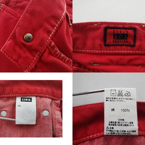 Op de afbeelding: Close-up opnamen van rode denim jeans, met details zoals een knoopsluiting, stiksels en het label "EDWIN 503 REGULAR". Extra labels tonen wasvoorschriften en de samenstelling van de stof.