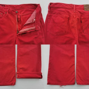 Op de afbeelding: Felrode denim jeans met een klassiek ontwerp met vijf zakken. De jeans hebben een knoop- en ritssluiting, riemlussen en het Edwin-merklabel op de achterkant. De jeans worden vanuit meerdere hoeken getoond.