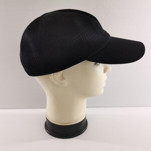 Puede incluir: Gorra de b&eacute;isbol negra con visera curva. La gorra tiene una textura similar a una malla en la parte superior y una visera s&oacute;lida. La gorra se muestra en una cabeza de maniqu&iacute; sobre un fondo blanco. Adecuada para deportes y uso casual.