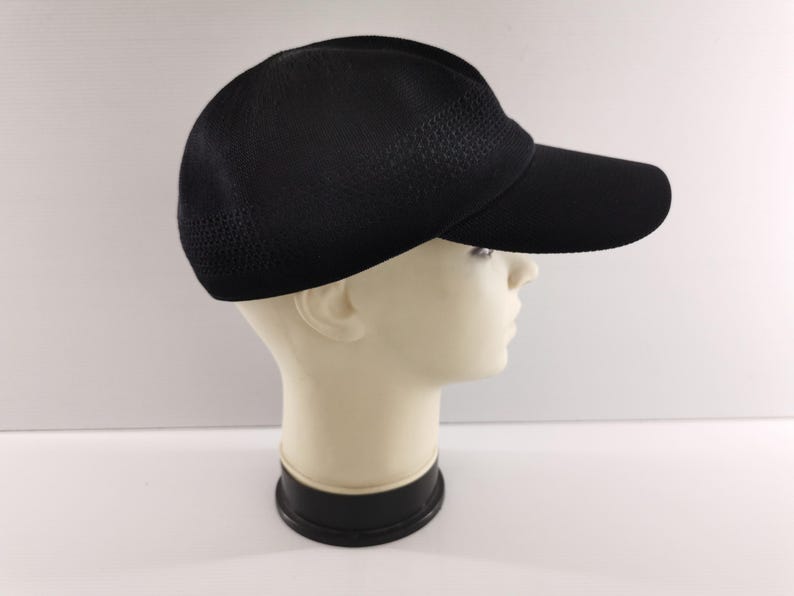Puede incluir: Gorra de b&eacute;isbol negra con visera curva. La gorra tiene una textura similar a una malla en la parte superior y una visera s&oacute;lida. La gorra se muestra en una cabeza de maniqu&iacute; sobre un fondo blanco. Adecuada para deportes y uso casual.