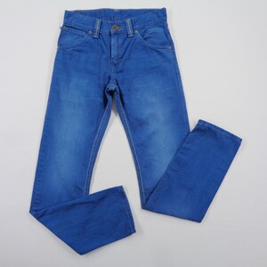 K&ouml;nnte beinhalten: Blaue Jeans aus Denim mit klassischem F&uuml;nf-Taschen-Design. Die Jeans haben einen Knopf- und Rei&szlig;verschluss, G&uuml;rtelschlaufen und Kontrastn&auml;hte. Das Kleidungsst&uuml;ck liegt flach auf einer wei&szlig;en Oberfl&auml;che.