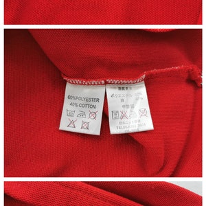 K&ouml;nnte beinhalten: Nahaufnahme eines roten Poloshirts mit dem Markennamen "courr&egrave;ges paris" auf dem Etikett. Das Shirt besteht aus 60 % Polyester und 40 % Baumwolle. Die Gr&ouml;&szlig;e ist M. Waschanweisungen sind ebenfalls sichtbar.