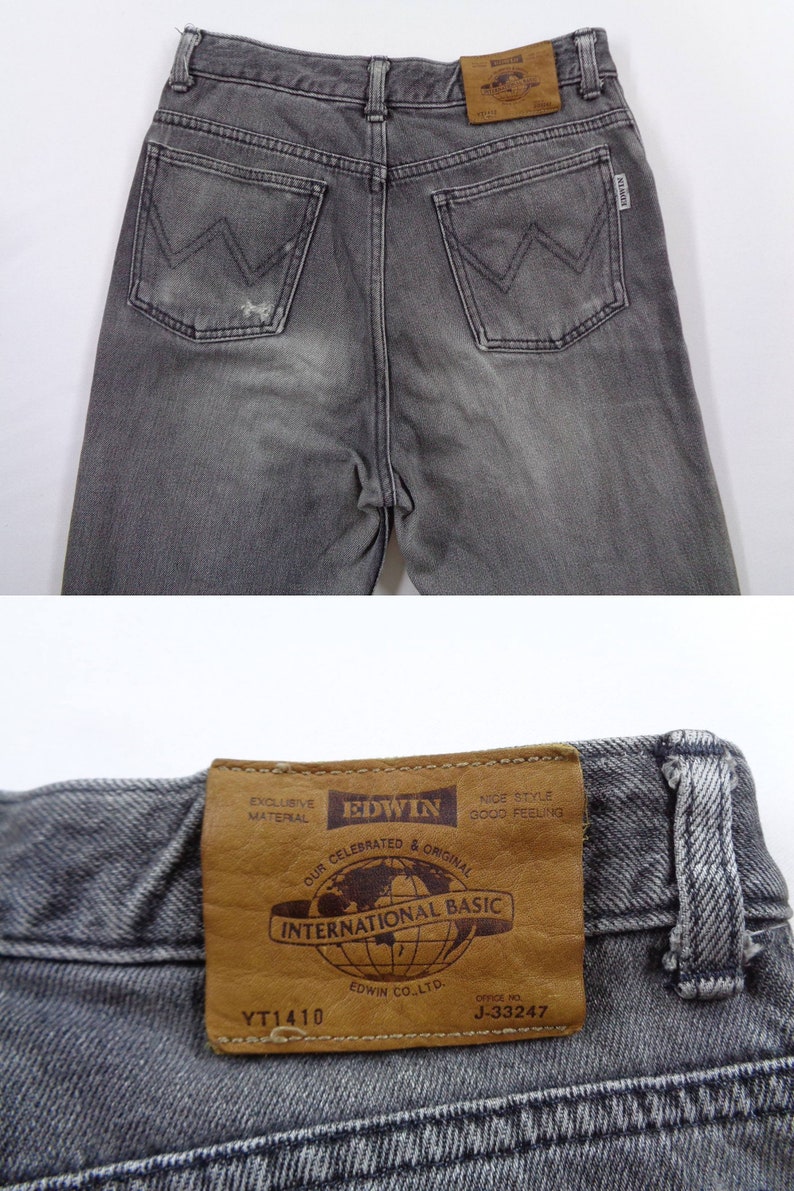 Puede incluir: Primer plano de unos vaqueros Edwin grises. Los vaqueros tienen un dise&ntilde;o cl&aacute;sico de cinco bolsillos con un parche de cuero en la cintura trasera. El parche dice "INTERNATIONAL BASIC" y "EDWIN CO. LTD.". Los vaqueros son de color gris descolorido.
