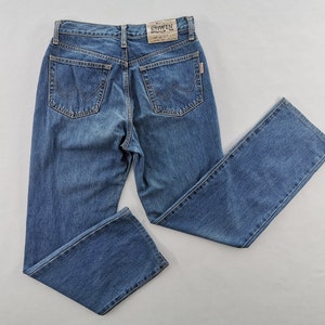 Puede incluir: Vaqueros de mezclilla azul con un dise&ntilde;o cl&aacute;sico de cinco bolsillos. Los vaqueros tienen un corte de pierna recta y un lavado descolorido. Los bolsillos traseros tienen un patr&oacute;n de costura distintivo. Una peque&ntilde;a etiqueta con la marca "EDWIN" es visible.