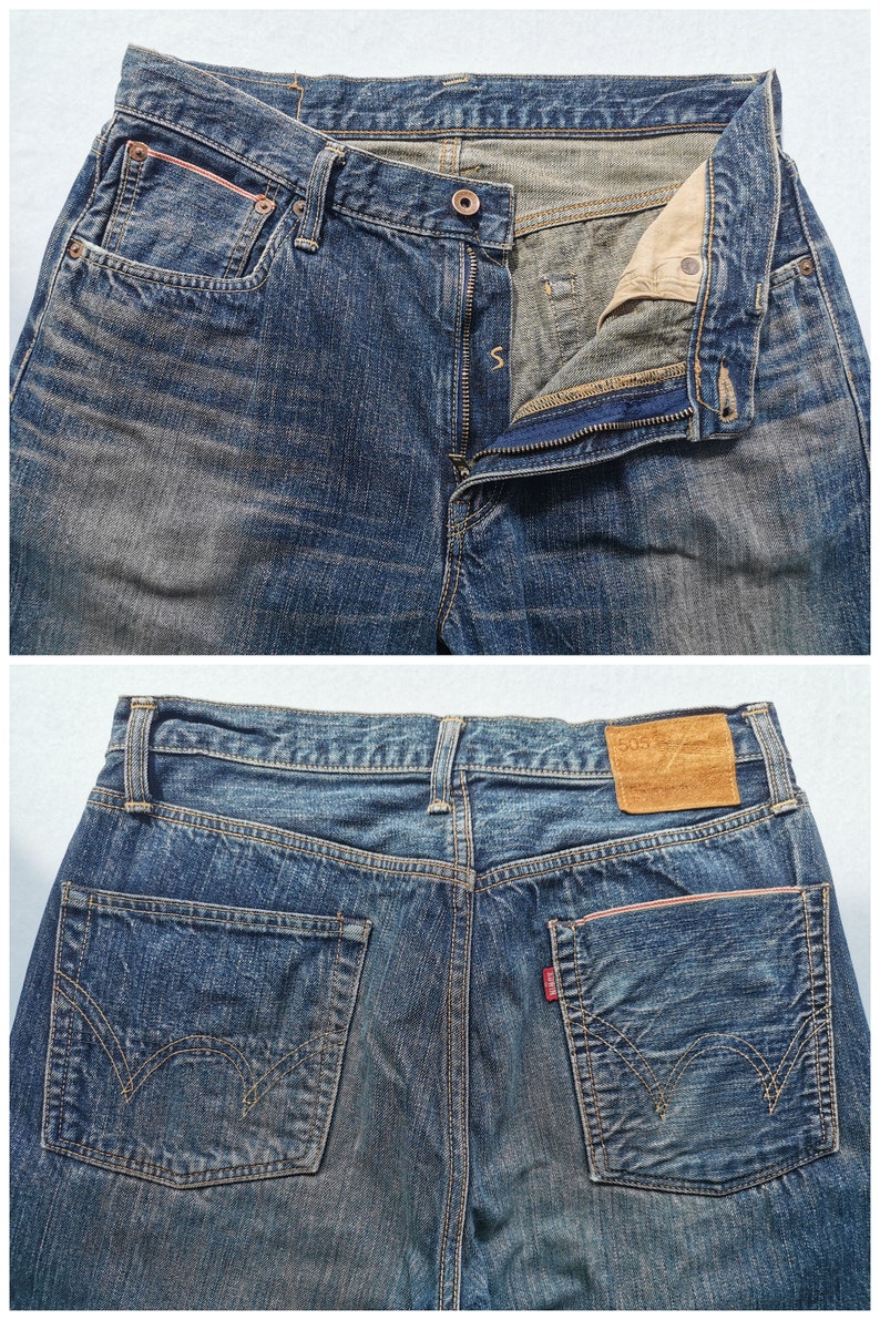 Pu&ograve; includere: Primo piano di jeans in denim blu con chiusura a bottone e cerniera. I jeans hanno tasche anteriori e posteriori, con una toppa in pelle marrone sul retro. Le tasche hanno accenti rossi. I jeans sono uno stile classico.