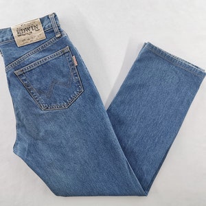 Puede incluir: Vaqueros de mezclilla azules con un dise&ntilde;o cl&aacute;sico de cinco bolsillos. Los vaqueros presentan un corte de pierna recta y un lavado descolorido. El bolsillo trasero tiene una costura distintiva en forma de W. Es visible un parche de cuero con el nombre de la marca.