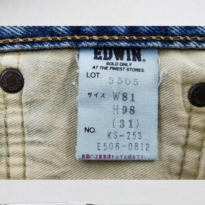 Puede incluir: Primer plano de unos vaqueros azules con una etiqueta. La etiqueta dice "EDWIN" e incluye informaci&oacute;n de tallas: W81, H98, y una cintura de 78.7 cm. Los vaqueros tienen costuras y remaches visibles.