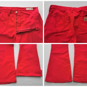 May include: Bright red Wrangler pants. The pants have a button and zipper closure, front and back pockets, and a Wrangler label on the back. The pants are a solid color and have a flared leg.