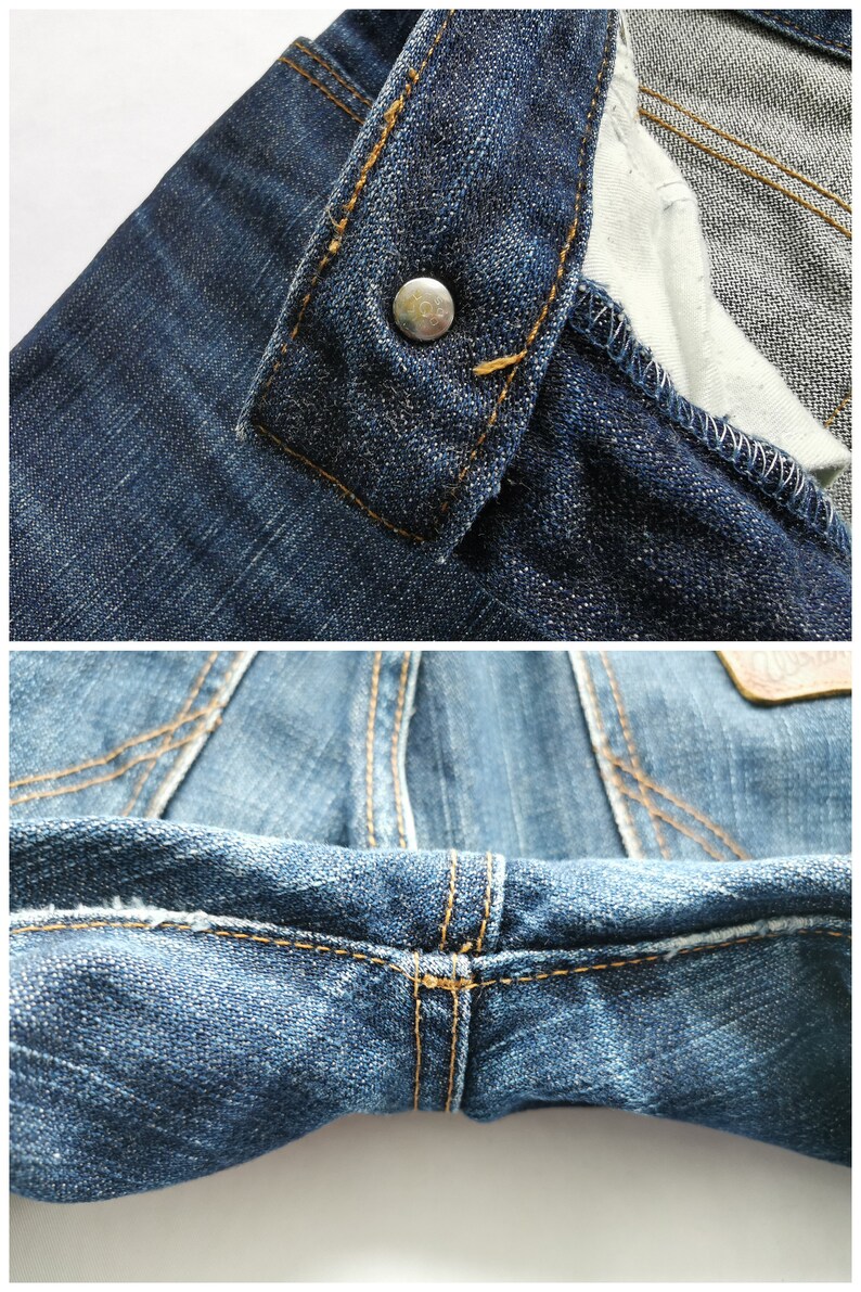 May include: Detailed view of blue denim jeans, highlighting the button fastening and stitching. The jeans feature a traditional design with prominent seams and a metal button. The fabric has a worn, textured appearance.