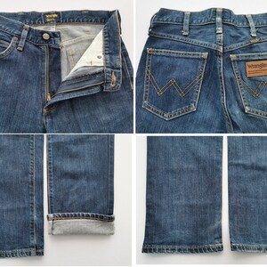 May include: Blue denim jeans with a classic five-pocket design. The jeans feature a button and zipper closure, belt loops, and the Wrangler logo on the back pocket. The jeans are shown in multiple views, including front, back, and close-ups of the details.