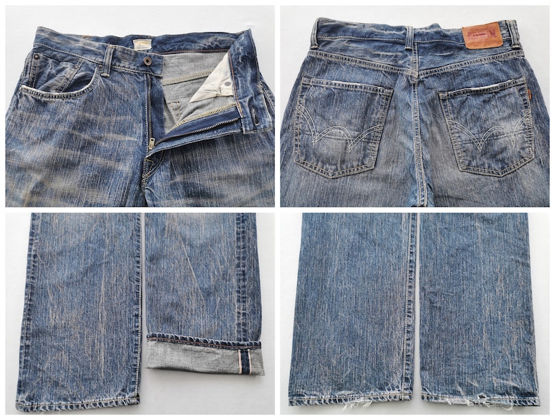 May include: Blue denim jeans with a faded wash. The jeans have a button and zipper closure, front and back pockets, and a leather patch on the back. The cuffs are rolled up, revealing a red selvedge detail. The jeans are a classic, casual style.