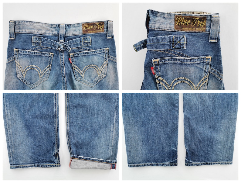 May include: Blue denim jeans with a faded wash, featuring a unique back design with a belt loop detail. The jeans have decorative stitching on the back pockets and a red tag. The label reads "Blue Trip".