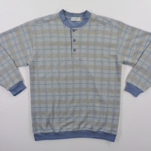 Puede incluir: Camisa de manga larga a cuadros azul claro y beige con cuello redondo y tres botones. La camisa tiene pu&ntilde;os azules y dobladillo azul. La camisa est&aacute; hecha de un material suave y c&oacute;modo.