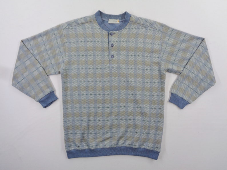 Puede incluir: Camisa de manga larga a cuadros azul claro y beige con cuello redondo y tres botones. La camisa tiene pu&ntilde;os azules y dobladillo azul. La camisa est&aacute; hecha de un material suave y c&oacute;modo.