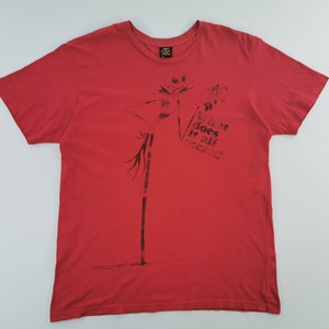 May include: Red t-shirt featuring a black graphic of Jack Skellington from The Nightmare Before Christmas. The shirt also has the text "What does it all mean?" printed on the front.