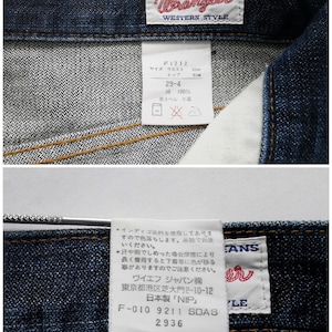 May include: Close-up of dark wash denim jeans with the "Lady Wrangler" label. The label includes the text "AUTHENTIC JEANS WESTERN STYLE". A tag shows waist size 63cm and hip size 91cm. The jeans are made of 100% cotton.