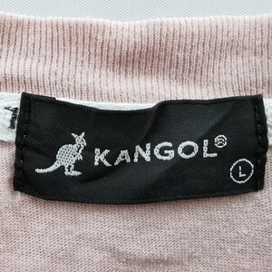 May include: Close-up of a pink t-shirt with a black label. The label features the white text "KANGOL" with a kangaroo logo and the size "L". A white tag with the text "GO" is visible.