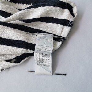 Puede incluir: Primer plano de una tela a rayas blancas y azul marino. Una etiqueta con texto japon&eacute;s y el n&uacute;mero 38 est&aacute; sujeta con alfileres. La tela parece ser un material de punto o tejido.